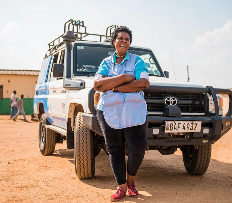 A Zambia team member standing in front of an MSI outreach vehicle